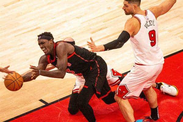 Pascal Siakam (i) de los Toronto Raptors intenta agarrar el balón ante Nikola Vucevic de los Chicago Bulls este 12 de abril de 2023, en un partido de los play-in de la NBA en Toronto (Canadá). EFE/ Julio César Rivas
