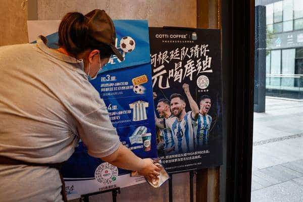 Un empleado limpia carteles promocionales con imágenes de los jugadores argentinos Leandro Paredes, Lionel Messi y Enzo Fernández de Selección Argentina en una cafetería de Beijing, China.EFE/EPA/MARK R. CRISTINO