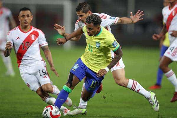 Yoshimar Otún (i) y Aldo Corzo (d) de Perú disputan el balón con Rodrygo de Brasil hoy, en un partido de las Eliminatorias Sudamericanas para la Copa Mundial de Fútbol 2026. EFE/ Paolo Aguilar