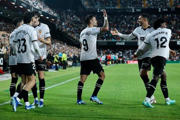 El delantero del Valencia, Hugo Duro (c), celebra con sus compañeros el segundo gol de su equipo durante el encuentro correspondiente a la jornada 10 de primera división que disputan hoy lunes frente al Cádiz en el estadio de Mestalla, en Valencia. EFE / Biel Aliño.
