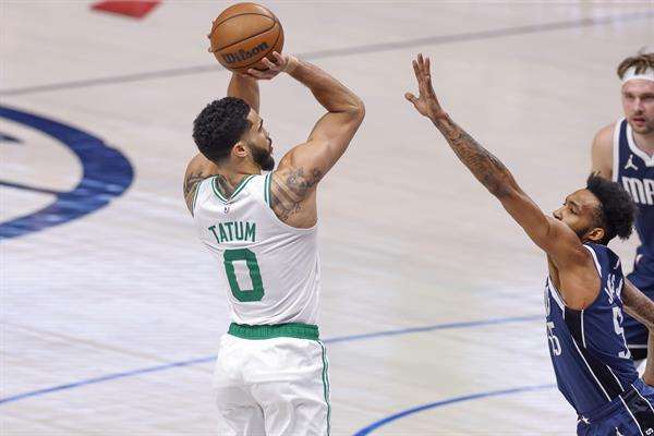 El jugador de los Celtics de Boston Jayson Tatum (i) toma un tiro sobre el delantero de los Mavericks de Dallas Derrick Jones Jr. (d) durante la primera mitad de un partido de la NBA. EFE/EPA/ADAM DAVIS