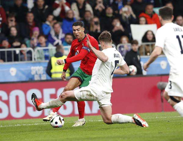 El portugués Cristiano Ronaldo (i) trata de superar al defensa esloveno Jaka Bijol, durante el amistoso que disputaron ambas selecciones en Liubliana. EFE/EPA/ANTONIO BAT