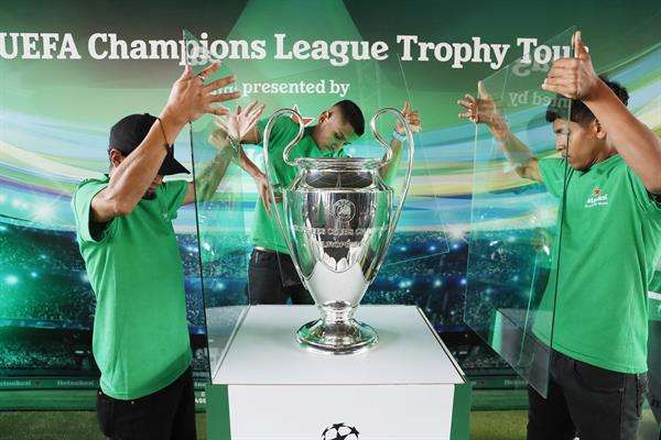 Un grupo de trabajadores de logística fue registrados este jueves, 11 de abril, al proteger con vidrios el trofeo de la Liga de Campeones de la UEFA, conocida popularmente como la 'Orejona', durante un tour de exhibición, en Bogotá (Colombia). EFE/Carlos Ortega