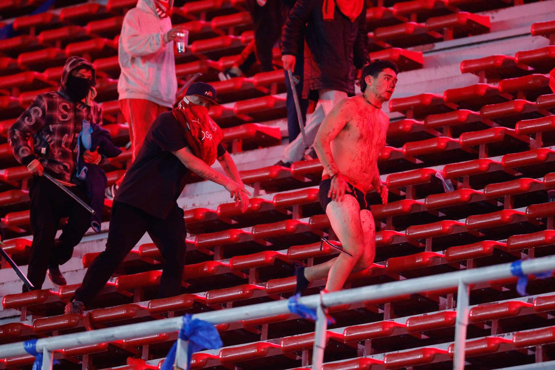 Hinchas se enfrentan, en un partido de los octavos de final de la Copa Sudamericana entre Independiente y Universidad de Chile en el estadio Libertadores de América en Avellaneda (Argentina). EFE/ Juan Ignacio Roncoroni.
