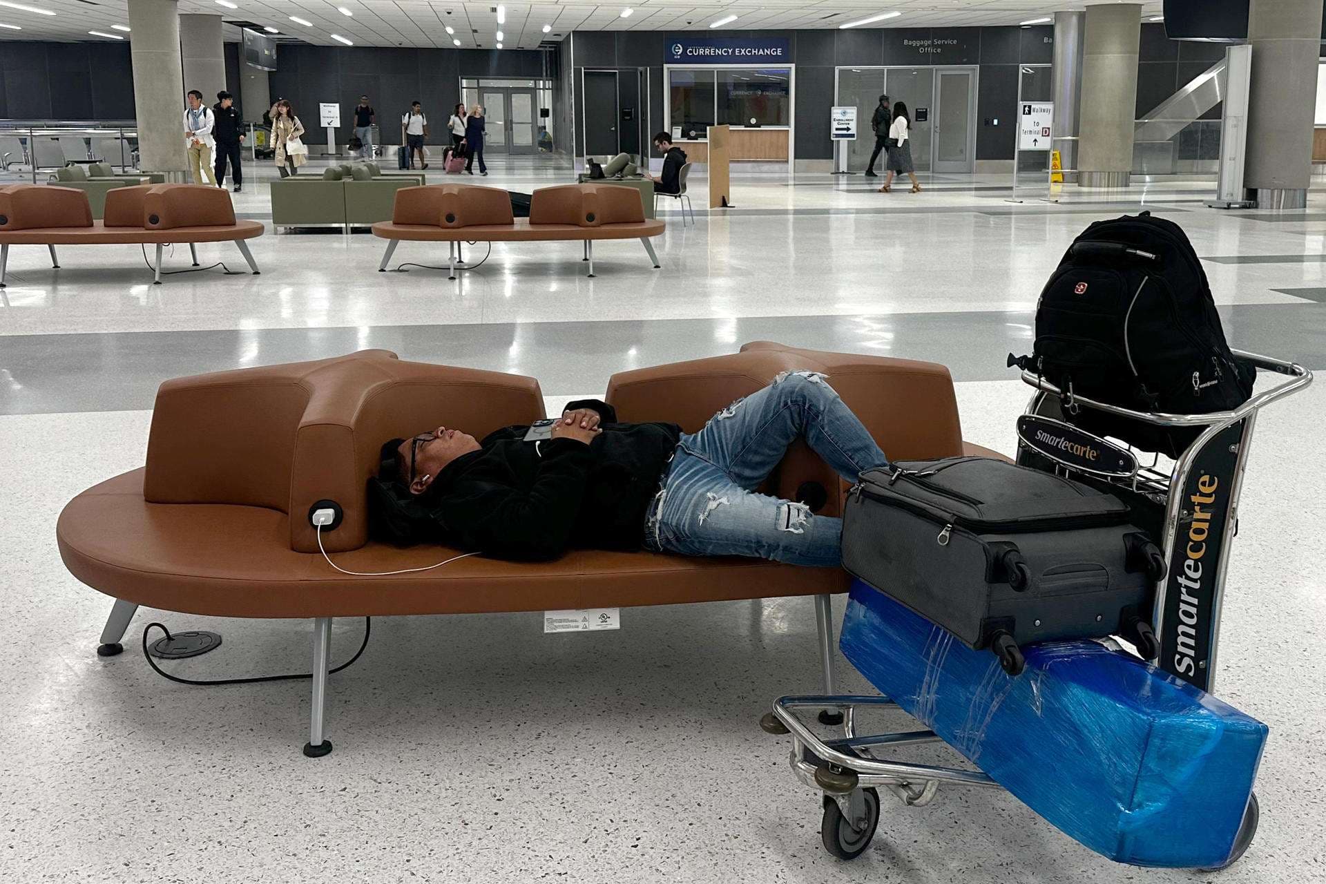 Un pasajero duerme en un pasillo del aeropuerto internacional George Bush este viernes, en Houston (Estados Unidos). EFE/ Carlos Ramírez