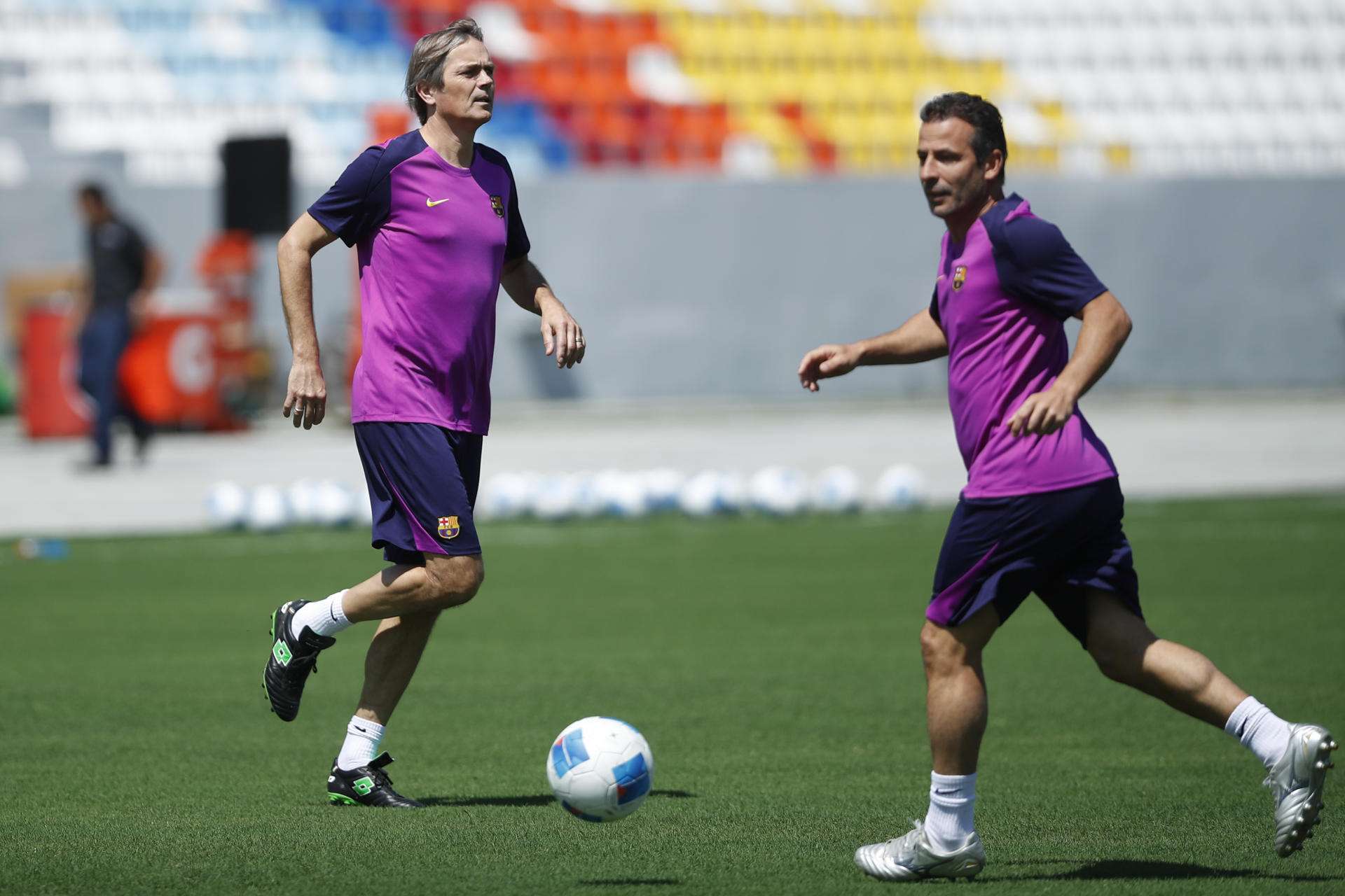 Los exjugadores del FC Barcelona Phillip Cocu (i) y Ludovic Giuly participan en un entrenamiento en el estadio Jorge 'Mágico' González, en El Salvador. EFE/Rodrigo Sura