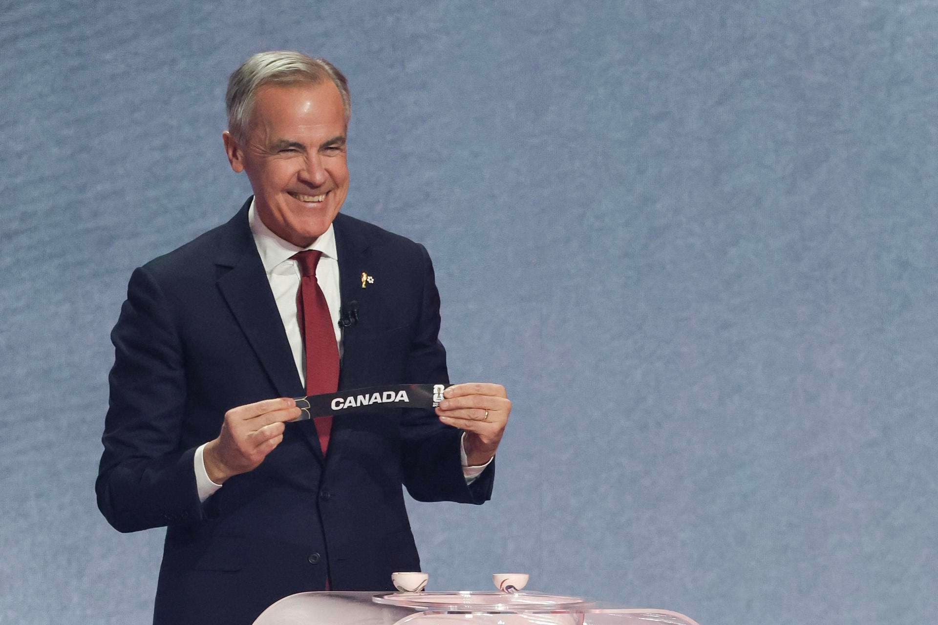 El primero ministro de Canadá, Mark Carney, sostiene un papel con el nombre de su país durante el sorteo del Mundial de Fútbol FIFA 2026. EFE/ Octavio Guzmán