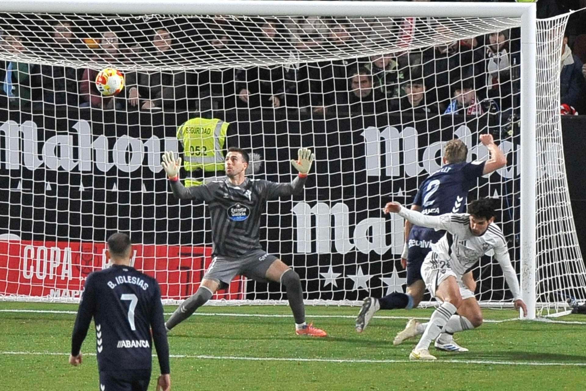 El guardameta del Celta, Iván Villar (i), intenta detener el remate del defensa del Albacete, Jesús Vallejo (d), en la jugada que ha significado el segundo gol del equipo albaceteño durante el encuentro correspondiente a los dieciseisavos de final de la Copa del Rey que disputaron Albacete y Celta en el estadio Carlos Belmonte de Albacete. EFE / Manuel Podio.