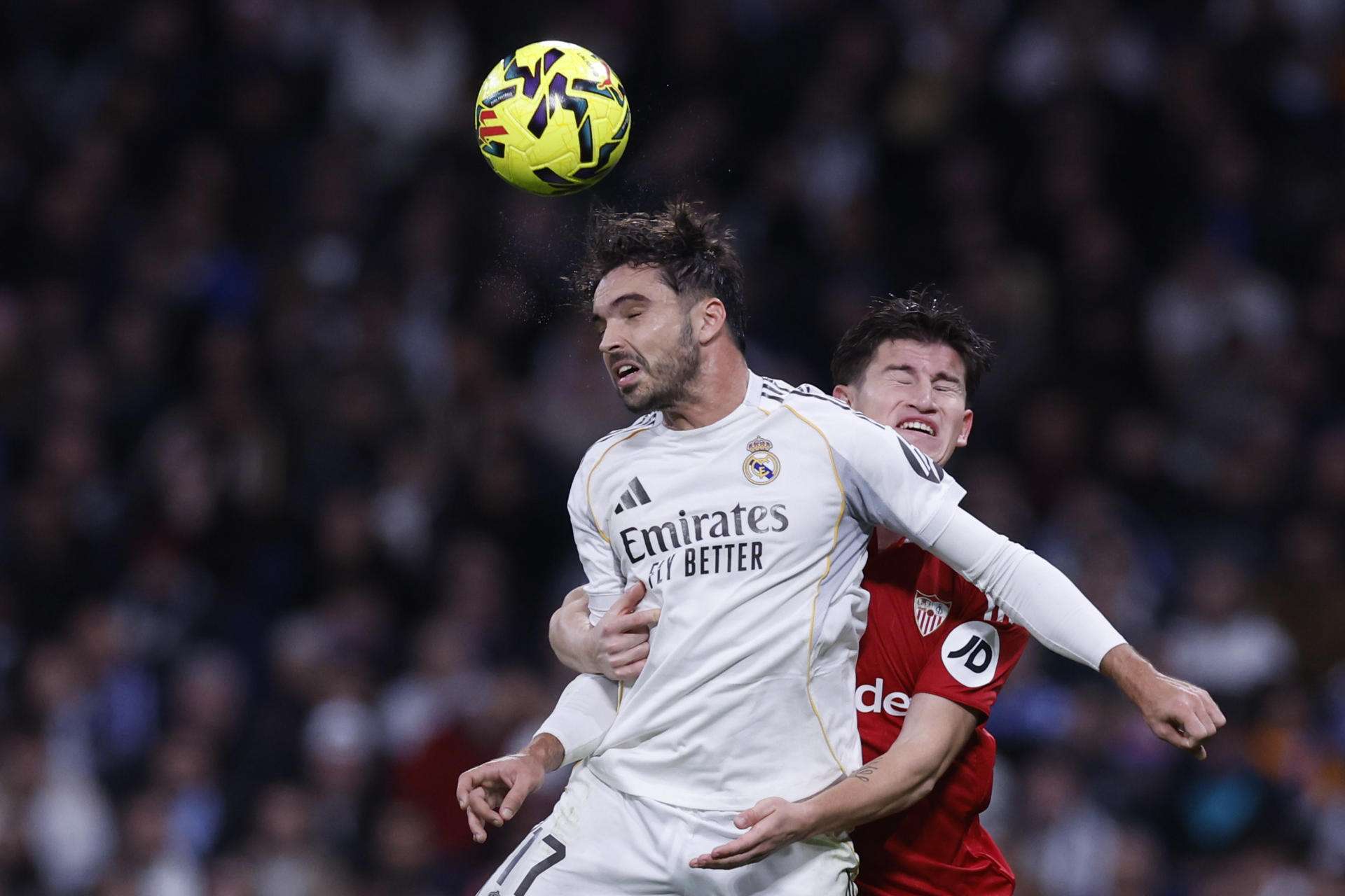 El defensa del Real Madrid Raúl Asencio (i) disputa un balón con el centrocampista del Sevilla Joaquín Martínez en el estadio Santiago Bernabéu, en Madrid. EFE/ Javier Lizón