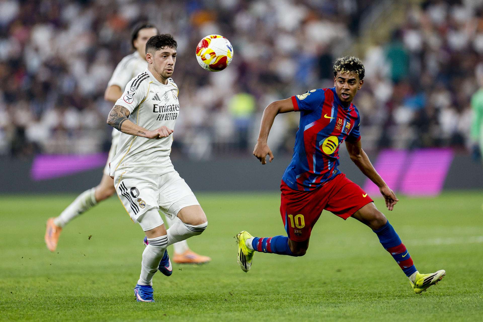 El delantero del FC Barcelona Lamine Yamal (d) disputa un balón con el centrocampista del Real Madrid Fede Valverde (i) durante la final de la Supercopa de España entre el FC Barcelona y el Real Madrid, este domingo en el estadio Ciudad Deportiva del Rey Abdalá de Yeda (Arabia Saudí). EFE/ Kai Försterling