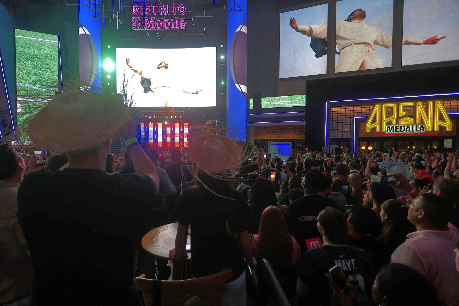 Personas observan la transmisión del espectáculo del cantante Bad Bunny en el Super Bowl de Estados Unidos este domingo, en San Juan (Puerto Rico). EFE/ Thais Llorca