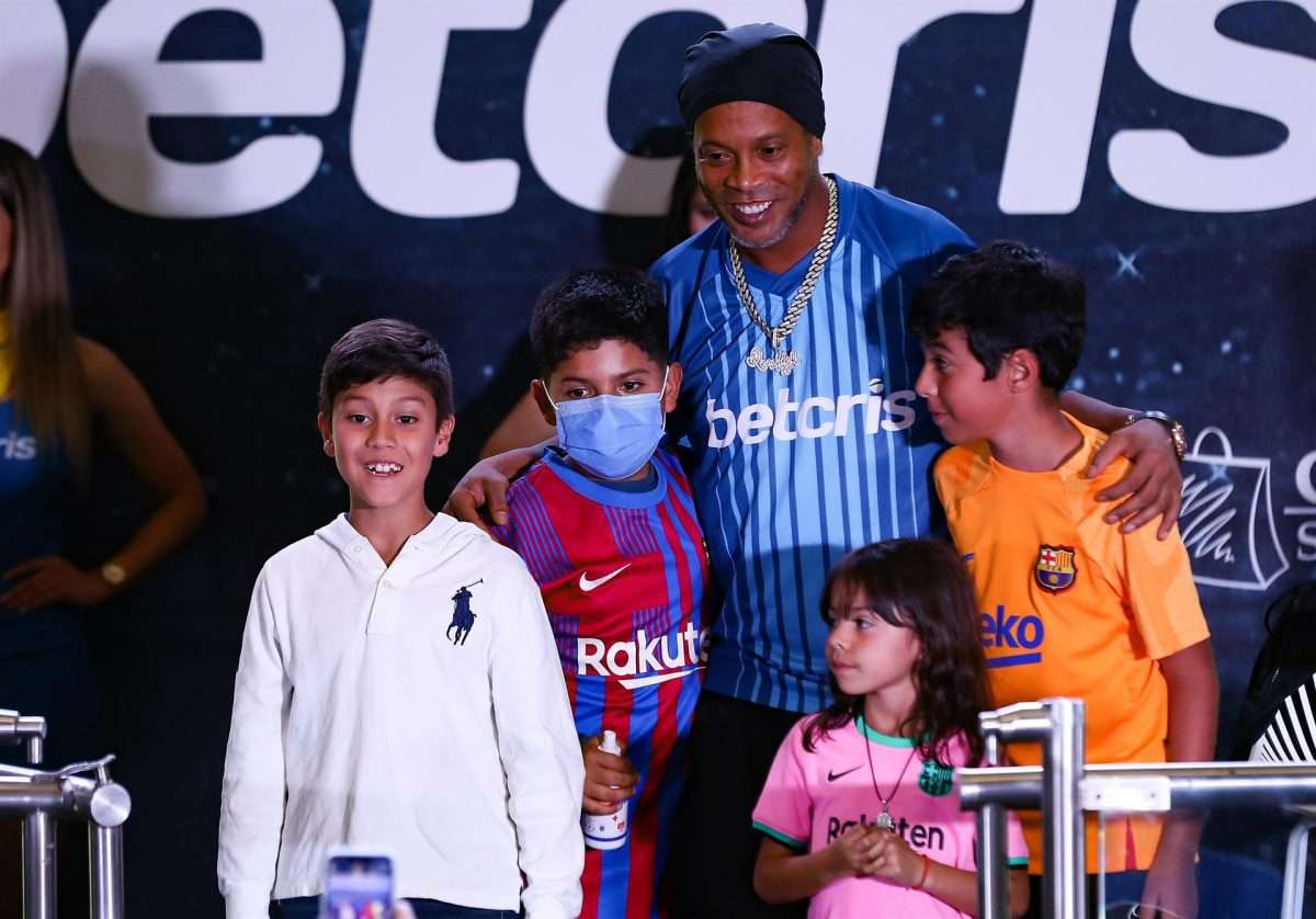 El ex futbolista brasileño Ronaldinho Gaúcho posa con niños en un concurso de fútbol-tenis y de habilidades dedicado a su figura, hoy, en un concurrido centro comercial de Quito (Ecuador). EFE/José Jácome