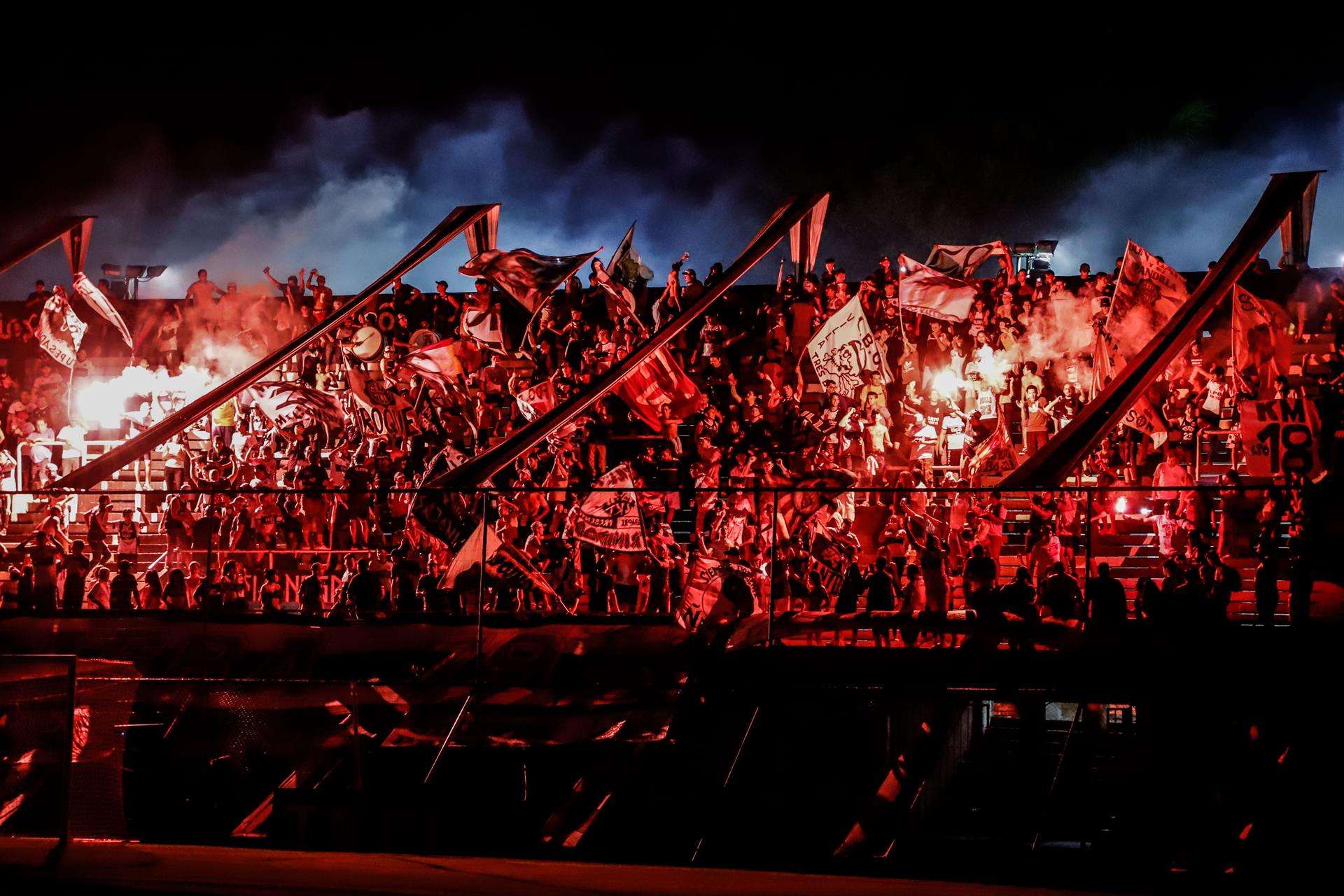 Fotografía de archivo en la que se registró a aficionados del club paraguayo de fútbol Olimpia, al encender bengalas, en las tribunas del estadio Manuel Ferreira, en Asunción (Paraguay). EFE/Nathalia Aguilar