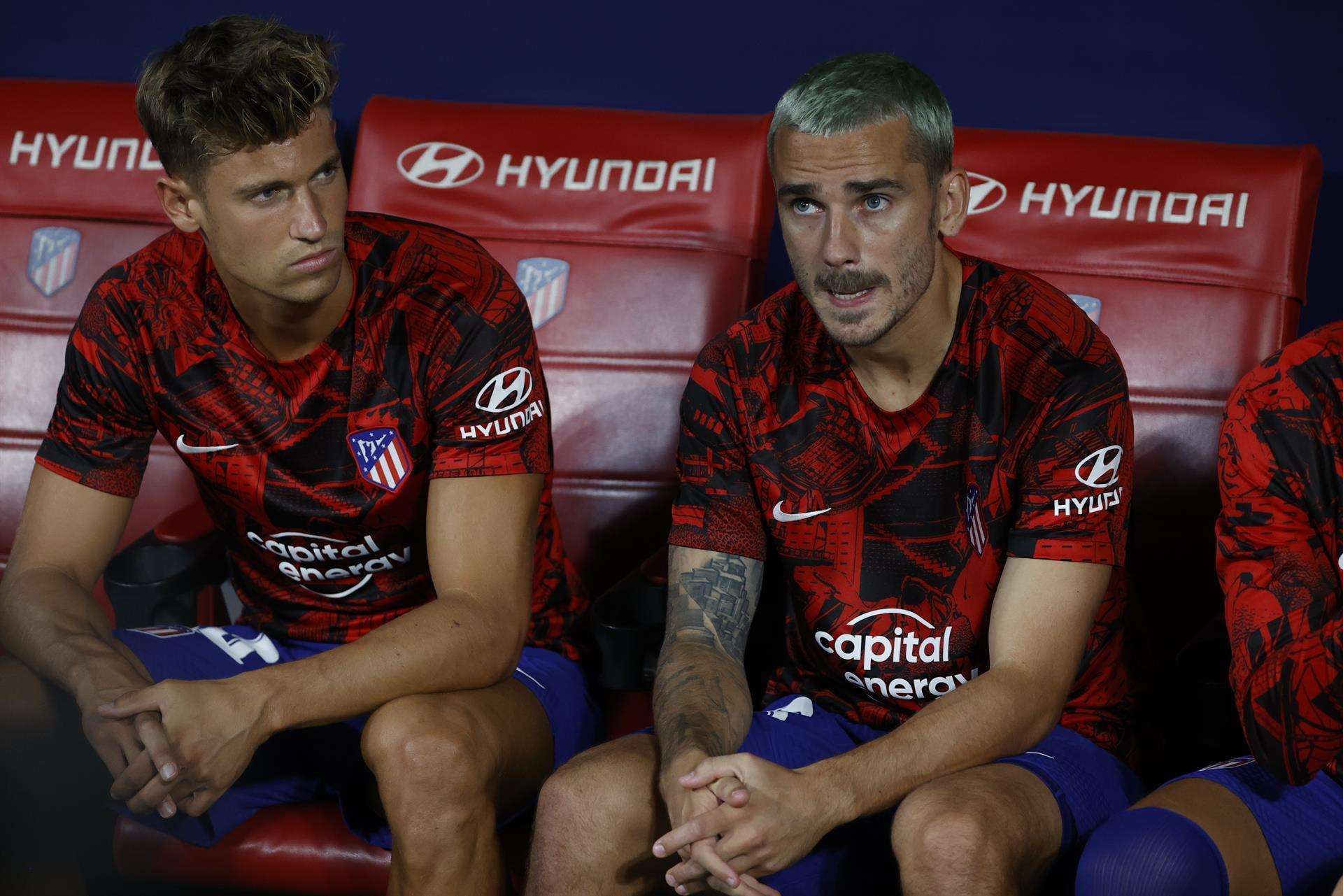 Antoine Griezmann junto a su compañero Marcos Llorente, en el banquillo del Atlético de Madrid durante el partido contra el Celta. EFE/ Juanjo Martin
