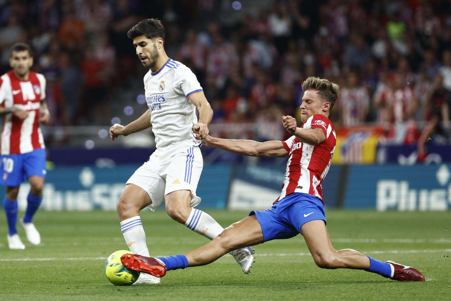 El centrocampista del Atlético de Madrid, Marcos Llorente, intenta cortar el avance de l jugador del Real Madrid, Marco Asensio, en el partido de la jornada 35 de la temporada pasada. EFE/ Rodrigo Jiménez.