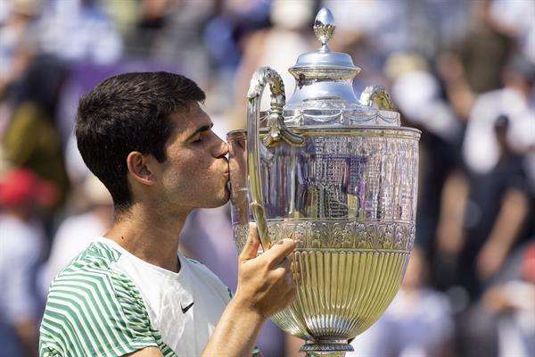 El español Carlos Alcaraz besa el trofeo tras vencer al australiano Alex de Miñaur en la final del torneo de Queen`s. EFE/TOLGA AKMEN