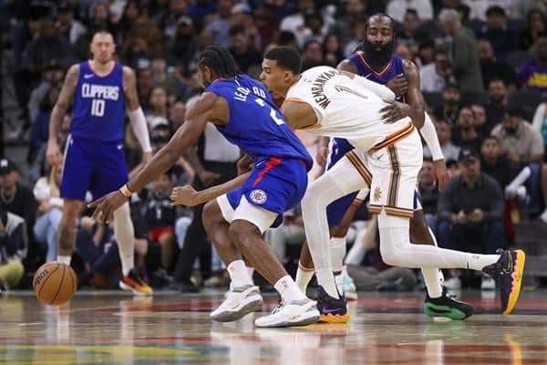 El delantero de los Clippers Kawhi Leonard (i) pasa por el centro de San Antonio Spurs Victor Wembanyama. EFE/EPA/ADAM DAVIS