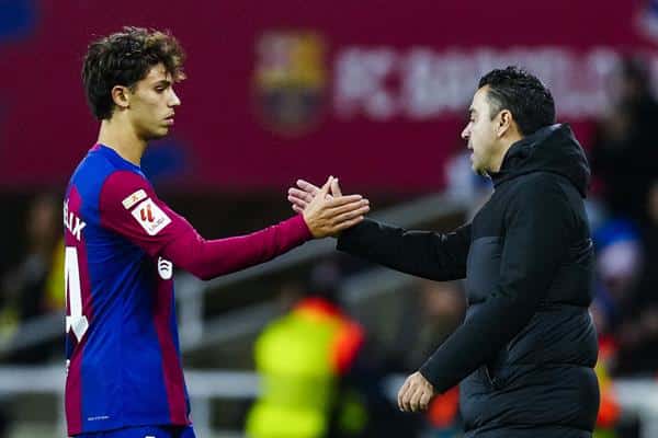 El delantero del Barcelona Joao Félix (i) choca la mano de su entrenador, Xavi Hernández en su camino hacia los vestuarios durante el partido de LaLiga de fútbol que FC Barcelona y Atlético de Madrid disputarono en el Estadio Olímpico de Montjuic. EFE/Alberto Estévez