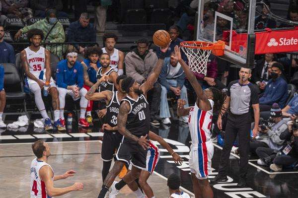 Royce ONeale (c), de los Nets de Brooklyn, fue registrado este sábado, 23 de diciembre al atacar el aro que defiende Isaiah Stewart (d), de los Pistons de Detroit, durante un partido de la NBA, en el coliseo Barclays Center, en Brooklyn (Nueva York, EE.UU.). EFE/Ángel Colmenares