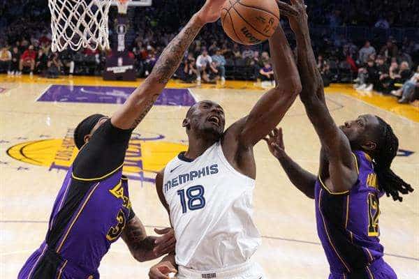 El pívot de los Memphis Grizzlies Bismack Biyombo (C) trata de anotar ante la oposición de Anthony Davis (I) y Taurean Prince, de Los Angeles Lakers. EFE/EPA/ALLISON DINNER SHUTTERSTOCK OUT