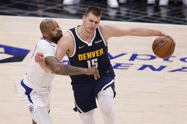 El jugador de Denver Nuggets Nikola Jokic (d) intenta mantener la posesión de la pelota mientras es custodiado por el jugador de Los Angeles Clippers P.J. Tucker (i) durante el tercer cuarto del partido de baloncesto de la NBA entre los Denver Nuggets y Los Angeles Clippers en Los Ángeles, California, EE. UU. EFE/EPA/CAROLINE BREHMAN