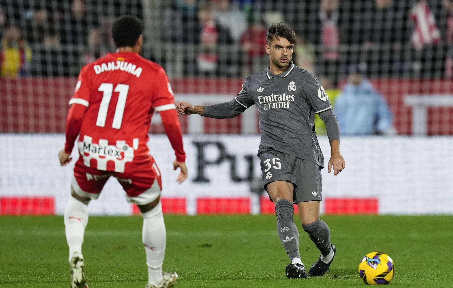 El defensa del Real Madrid Raúl Asencio (d) centra en el estadio Montilivi, en Girona en foto de archivo de Siu Wu.EFE