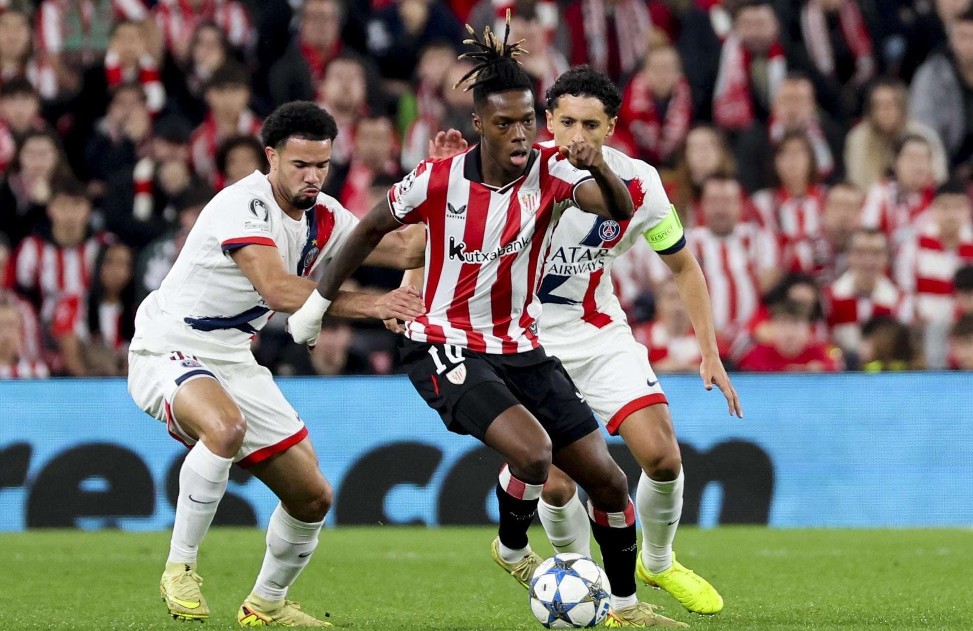 El delantero del Athletic Club, Nico Williams (c), intenta llevarse el balón ante los jugadores del PSG durante el encuentro correspondiente a la fase regular de la Liga de Campeones que disputan Athletic Club y PSG en el estadio de San Mamés, en Bilbao. EFE/Luis Tejido.