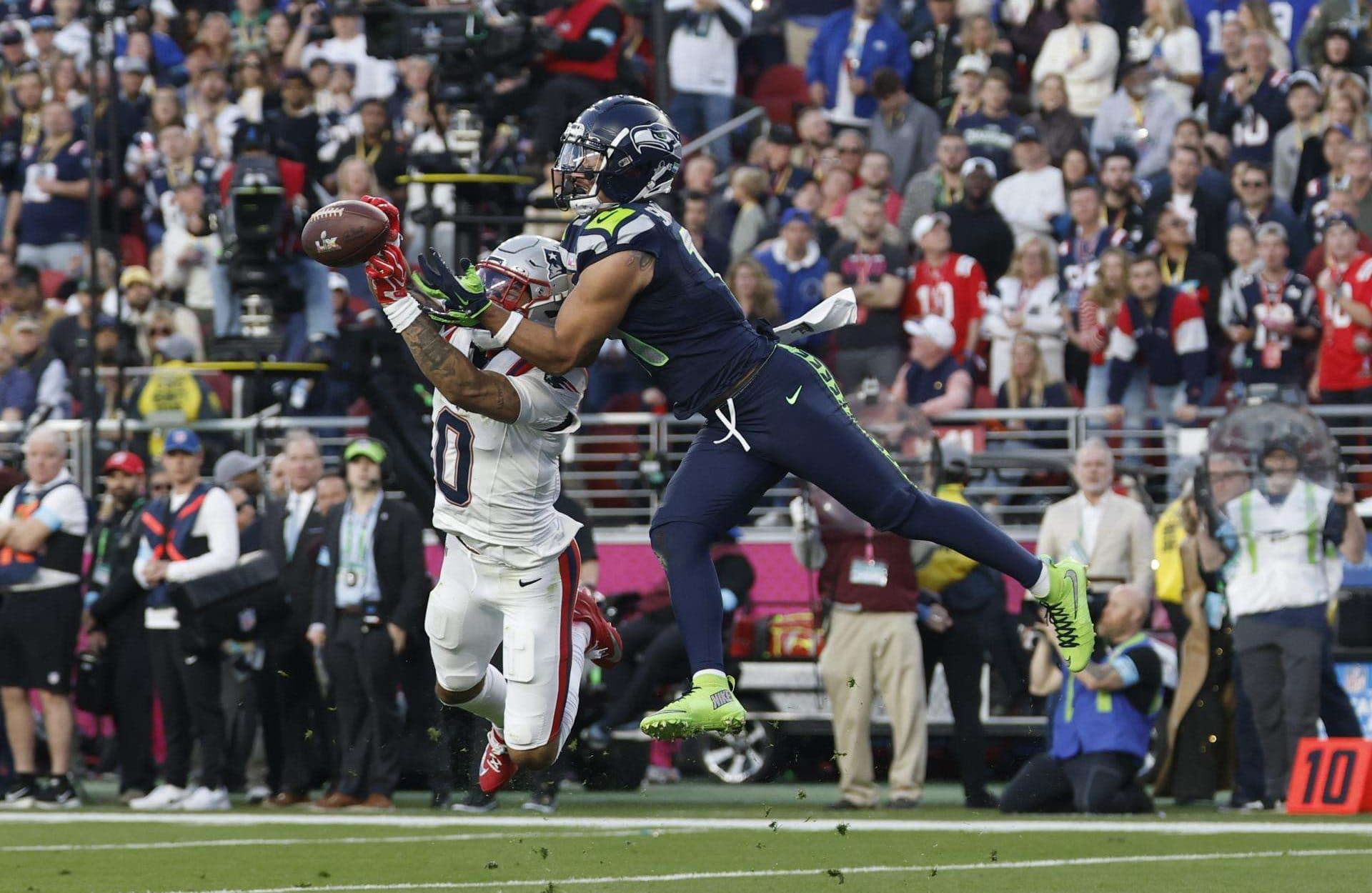 El 'wide receiver' de los Seattle Seahawks Jaxon Smith-Njigba (d) es neutralizado en su avance por el 'cornerback' de New England Patriots Christian Gonzalez (i) poco antes de abandonar lesionado en el tercer cuarto del Super Bowl LX que se juega este domingo en el Levis Stadium en Santa Clara (California). EFE/EPA/JOHN G. MABANGLO