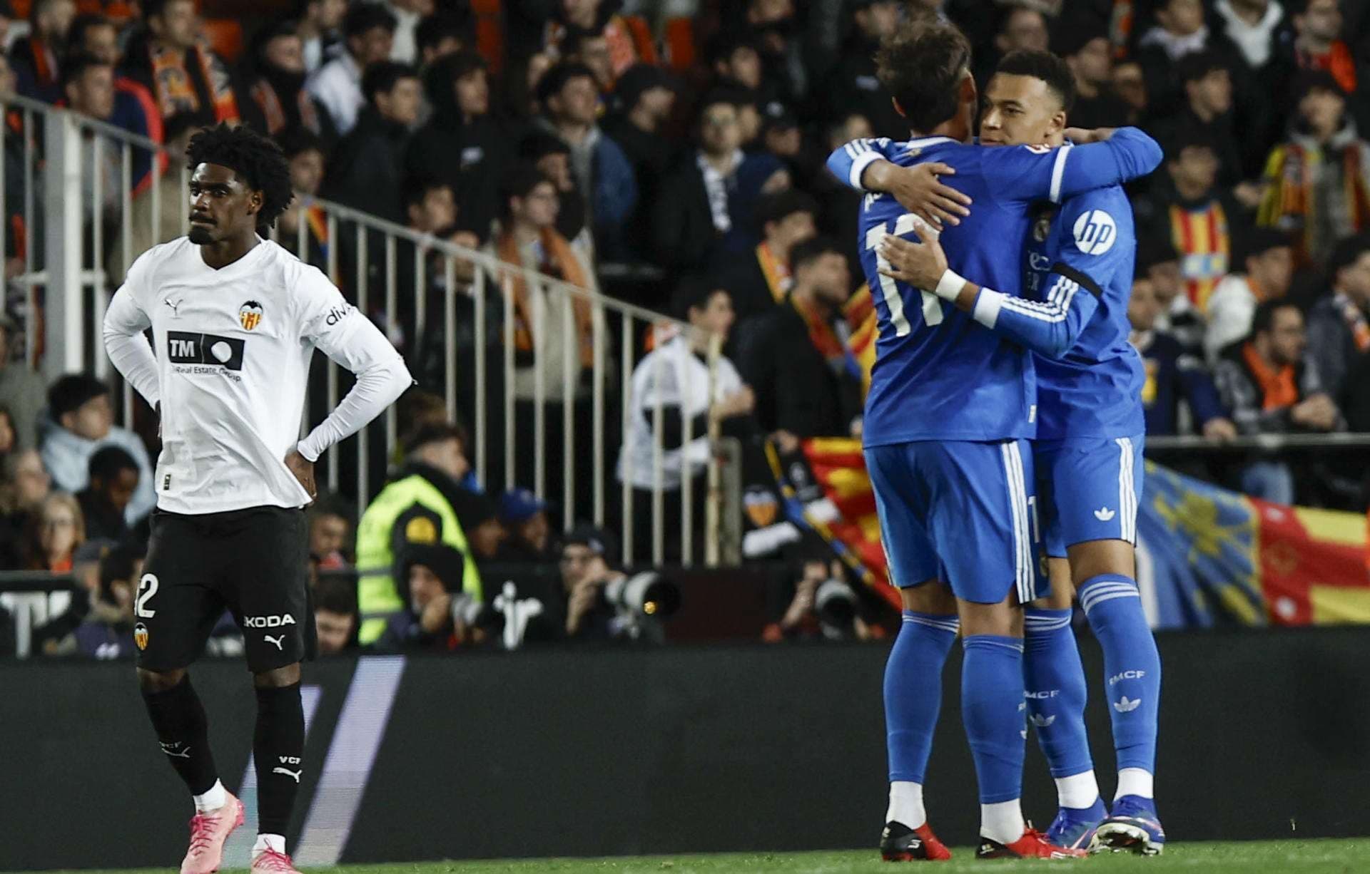 El delantero del Real Madrid Kylian Mbappé (d) celebra con Raúl Asencio (c) tras marcar el segundo gol, durante el partido de LaLiga de fútbol que Valencia CF y Real Madrid disputaron en el estadio de Mestalla. EFE/Biel Aliño